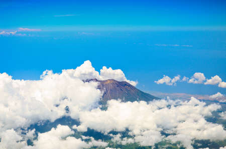 Aerial view of volcano Gunung Agung in Bali. Low clouds surrounds itの写真素材