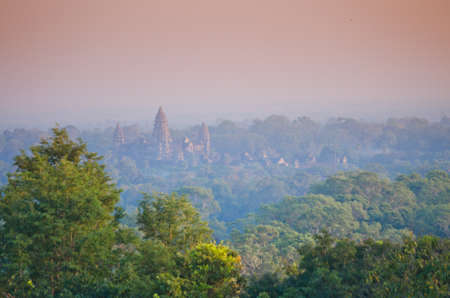 sun set over the jungle and some ruins at Angkor Wat Area in Cambodiaの写真素材