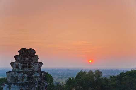sun set over the jungle and some ruins at Angkor Wat Area in Cambodiaの写真素材