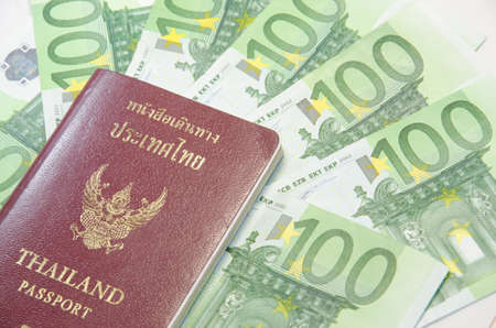 Close-up of 100 Euro banknotes and passport isolated on white background.の写真素材
