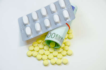 euro banknotes and tablets, symbol photo for costs of medications and health insurance.の写真素材