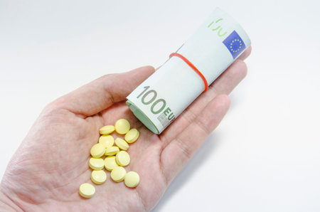 euro banknotes and tablets, symbol photo for costs of medications and health insurance.の写真素材