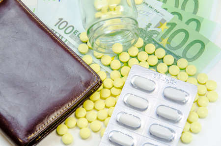 euro banknotes and tablets, symbol photo for costs of medications and health insurance.の写真素材