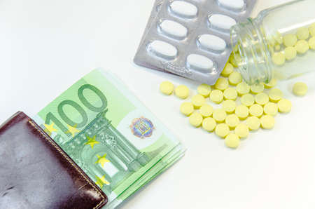 euro banknotes and tablets, symbol photo for costs of medications and health insurance.の写真素材