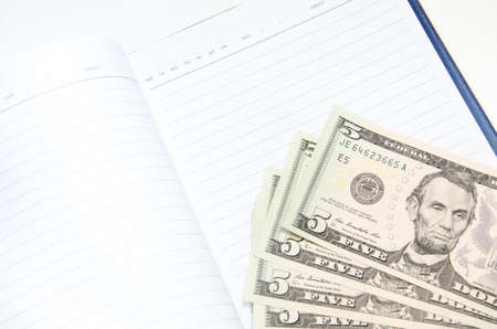 notebook on American 5 USD banknotes background. Space for copy inside.の写真素材
