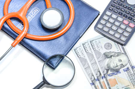 notebook ,stethoscope with us dollars and magnifying glassの写真素材