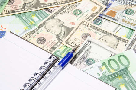 notebook with blue pen on American 5 USD banknotes background. Space for copy inside.の写真素材