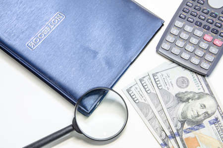 notebook with us dollars and magnifying glassの写真素材