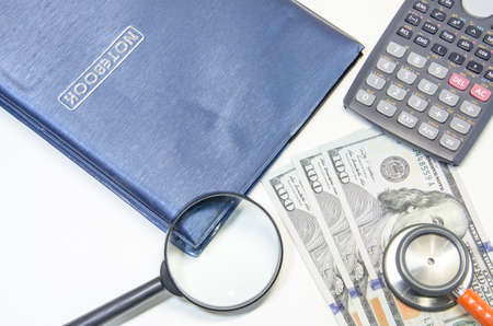 notebook with us dollars and magnifying glassの写真素材