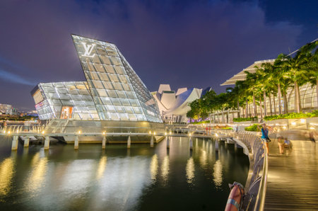 SINGAPORE - MAY 12: The futuristic building housing Louis Vuitton store reflect on the quiet waters of Singapore bay at twilight circa on May 12, 2014 in Singapore.のeditorial素材