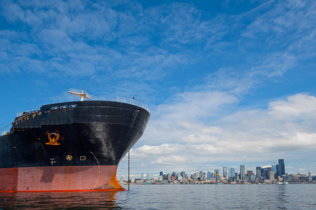 Bulk Carrier at anchor in Seattle's Elliott Bay on Sunny, windless day with city in backgroundのeditorial素材