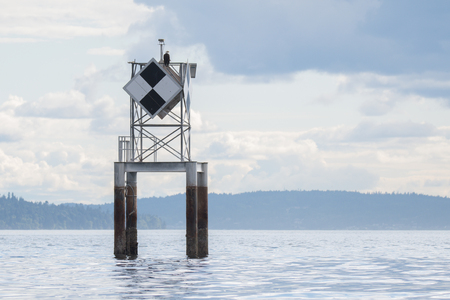 Calm, cloudy day.  Daymark positioned in West Seattle, WA.  The bald eagle was a bonusの写真素材