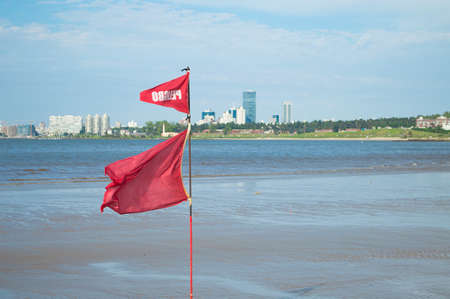 red flag waving on the Uruguayan coastの写真素材