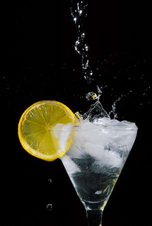Splashes of water with lemon on black backgroundの写真素材