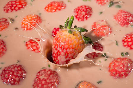 Strawberries falling in the yogurtの写真素材