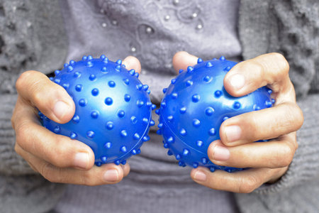 Old woman hands squeezing rehab balls