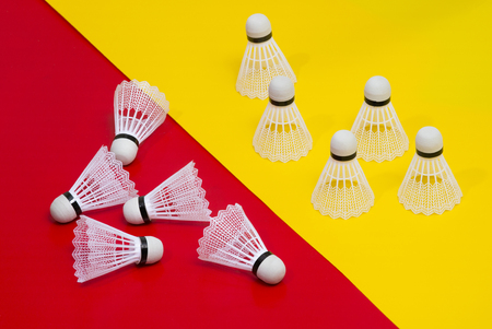 Badminton shuttlecocks and racket against a red and yellow  backgroundの写真素材