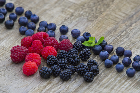 mix of blackberries, raspberries, blueberry on old wooden table background. top view with copy spaceの写真素材