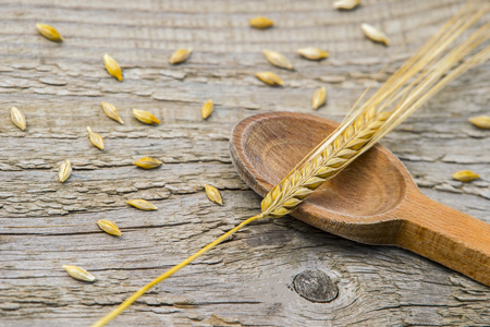 barley grains in wooden spoon on old wooden background.の写真素材