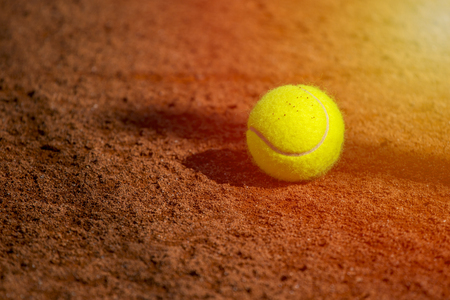 A lonely Tennis Ball on a Sand Courtの写真素材