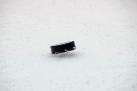 black hockey puck  jump on ice rink. Winter sport.の写真素材