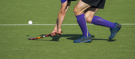 Field Hockey player, forcefully passing the ballの写真素材