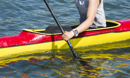Close-up of female kayaker paddling through water rapidsの写真素材