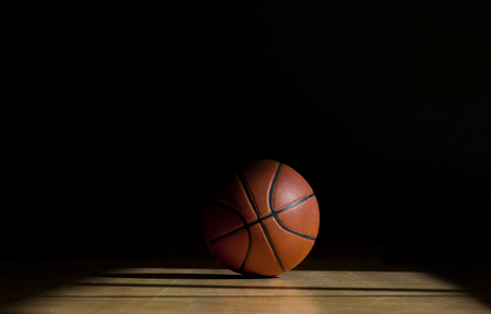 Basketball ball on the parquet with black backgroundの写真素材