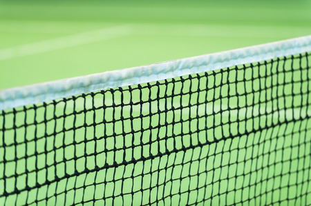 Net of tennis court on green wall backgroundの写真素材