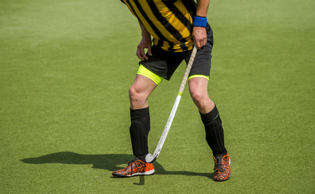 man field hockey player on the grass green backgroundの写真素材