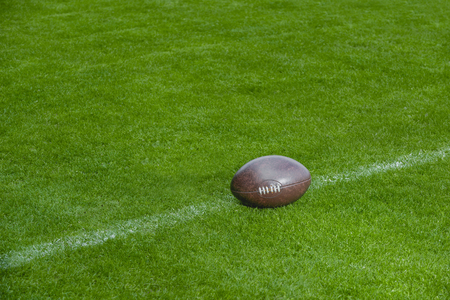 American football, rugby ball on green grass field backgroundの写真素材