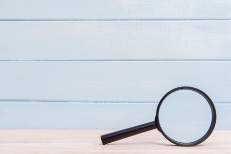 Magnifying glass on a pink wooden tableの写真素材