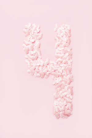 Number four collected from decorative pink hearts. Isolated on pink backgroundの写真素材