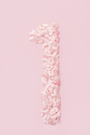 Number one collected from decorative pink hearts. Isolated on pink backgroundの写真素材