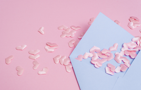 Small pink hearts with envelope, on pink background with copy spaceの写真素材