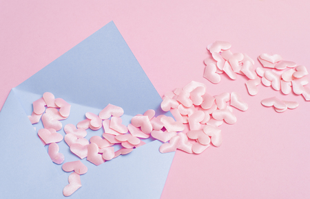Small pink hearts with envelope, on pink background with copy spaceの写真素材