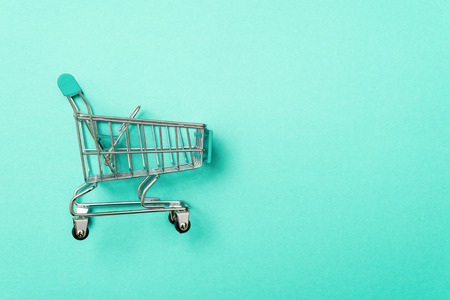close-up of shopping trolley on green background with some copy spaceの写真素材