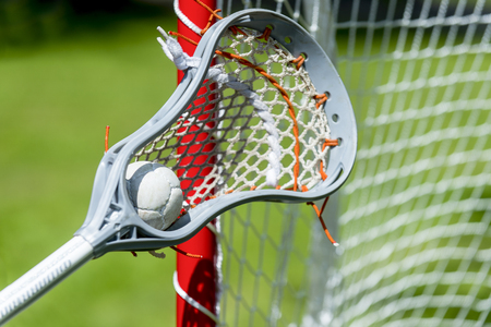 Abstract view of a lacrosse stick scooping up a ballの写真素材