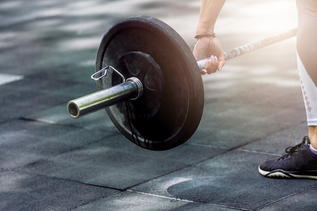 crossfit woman preparing for her weightlifting workout with a heavy dumbbellの写真素材