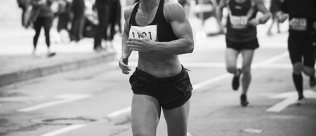 Unrecognizable muscular runner outdoors. Long distance running. Black and white.の写真素材