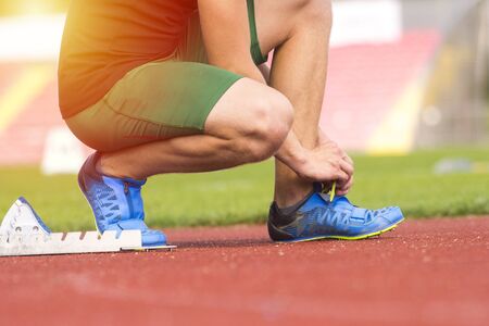 Athlete in the starting block waiting for the start in running trackの写真素材