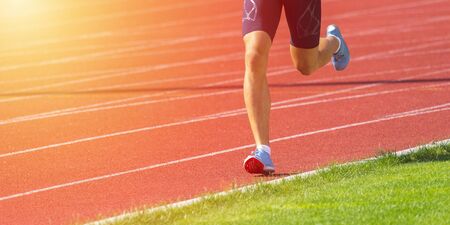 Athletics man running on the track fieldの写真素材