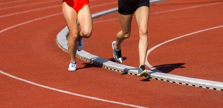 Athletics people running on the track field. Sunny dayの写真素材