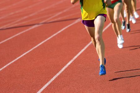 Athletics people running on the track field. Sunny dayの写真素材