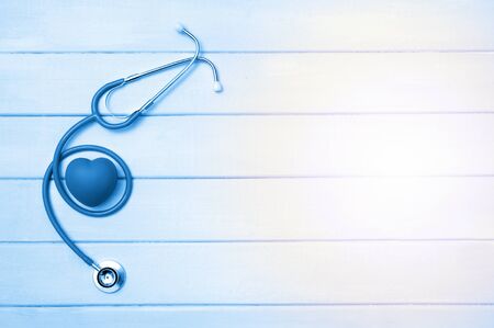 Stethoscope and heart on wooden background. Blue tonned.の写真素材
