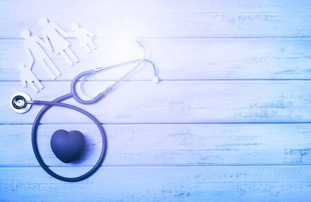 Medical Insurance Concept. Family cutout and Stethoscope on pink wooden backgroundの写真素材