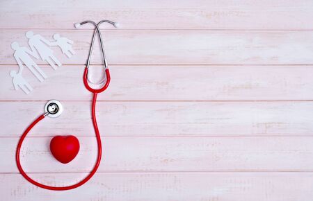 Medical Insurance Concept. Family cutout and Stethoscope on pink wooden backgroundの写真素材