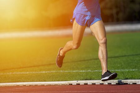 Athletics man running on the track fieldの写真素材