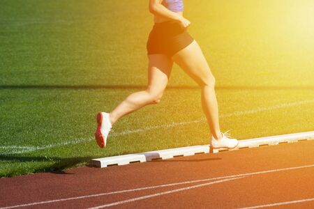 Athletics woman running on the track fieldの写真素材