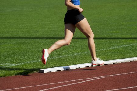 Athletics woman running on the track fieldの写真素材